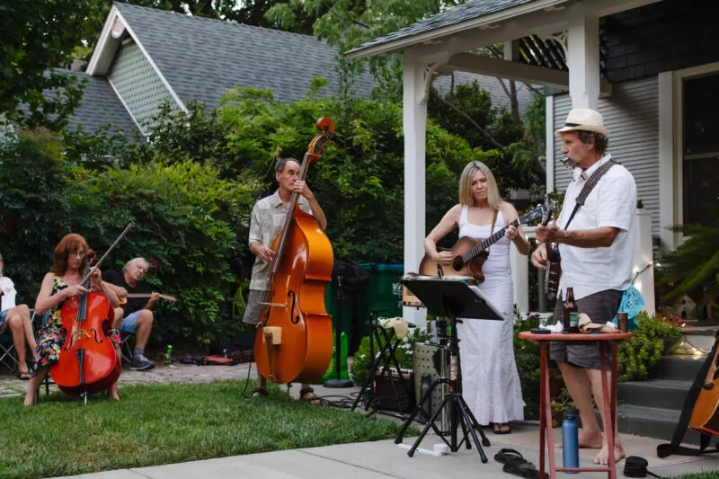 David Bilinski and Dana Hanson gather with friends in a casual acoustic performance in the front yard of this Barber neighborhood home.