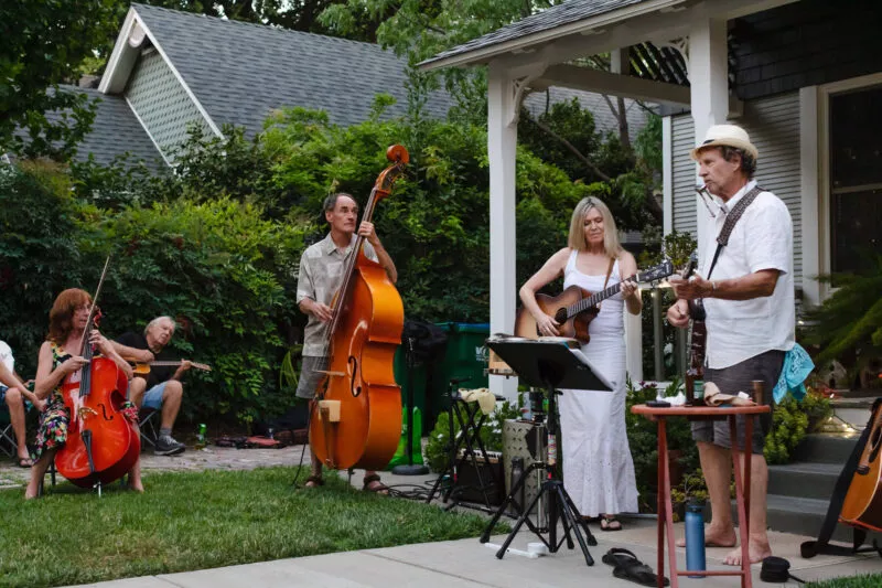 David Bilinski and Dana Hanson gather with friends in a casual acoustic performance in the front yard of this Barber neighborhood home.