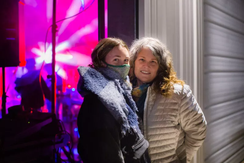 Watching the performance from the outside, 2 ladies view The Project, at the 2021 St Patty's Shindig.