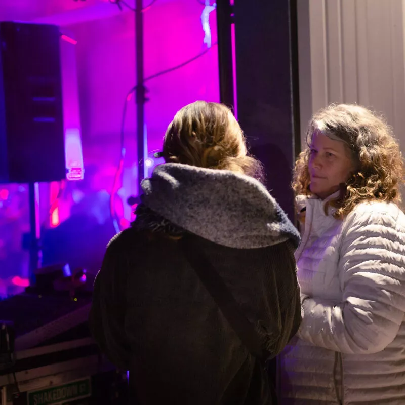 Watching the performance from the outside, 2 ladies view The Project, at the 2021 St Patty's Shindig.